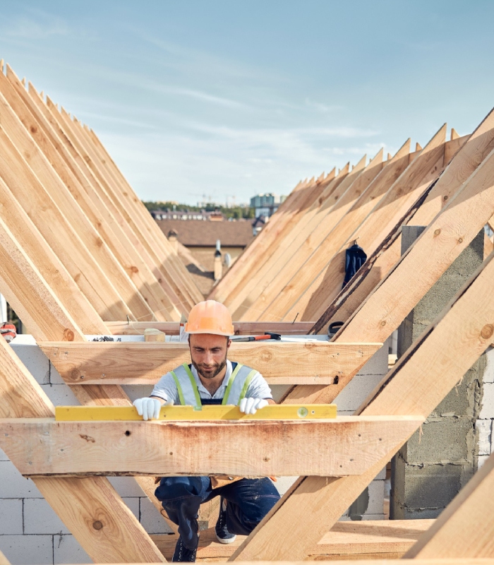 Charpentier vérifiant le niveau d'une structure de charpente en bois