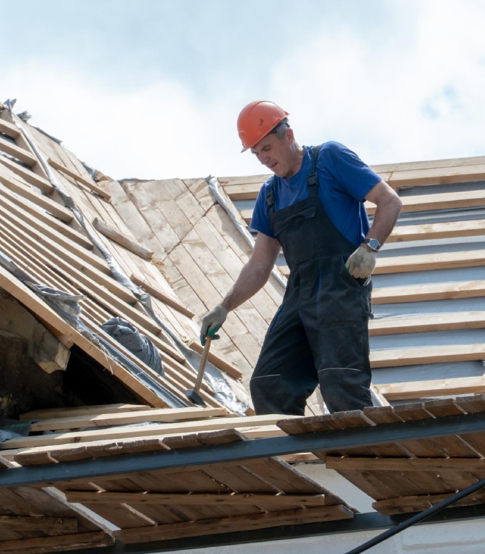 Couvreur réalisant des travaux de rénovation sur une toiture en bois